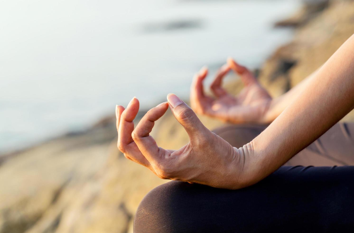 närbild av en kvinnas händer i meditation foto