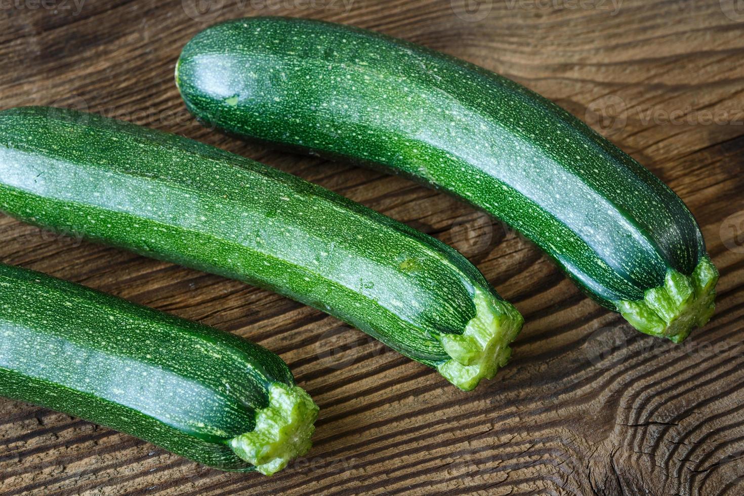 färsk zucchini på rustik trä- tabell foto