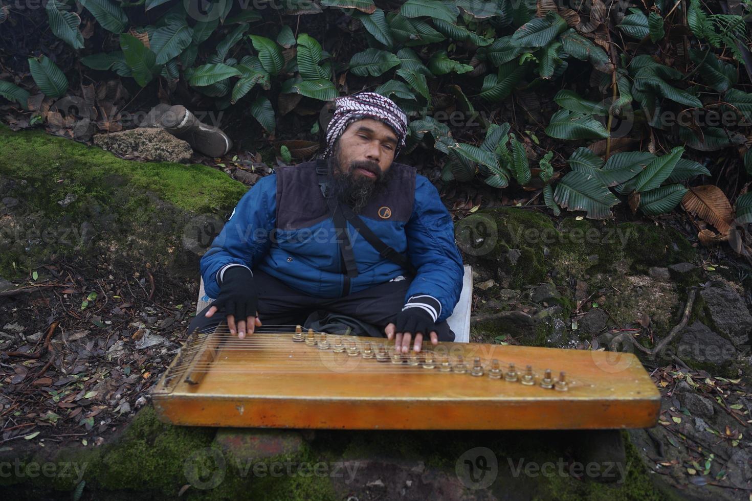 en man spelar kecapi traditionell Sundanesiska musik i de ciwidey, bandung,väst java, Indonesien. foto