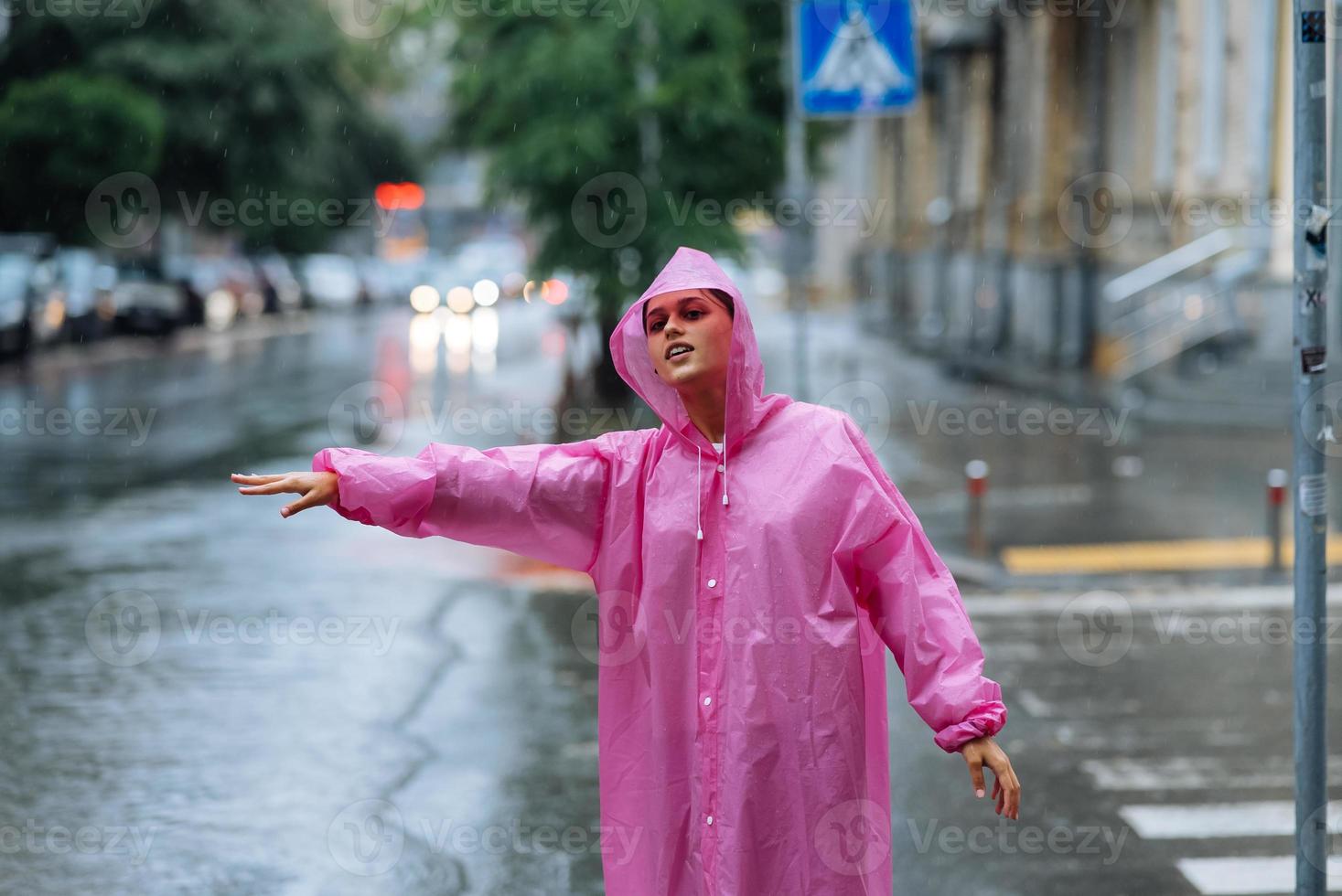 ung flicka påfrestande till sluta en cab. kvinna kallelse en taxi på en regnig dag. foto