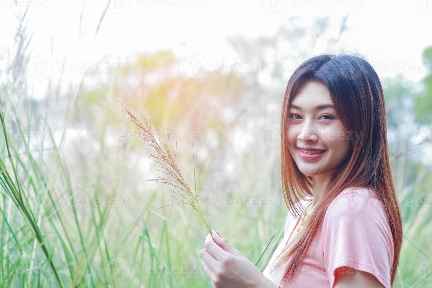 asiatisk kvinna som står och ler på naturbakgrund foto