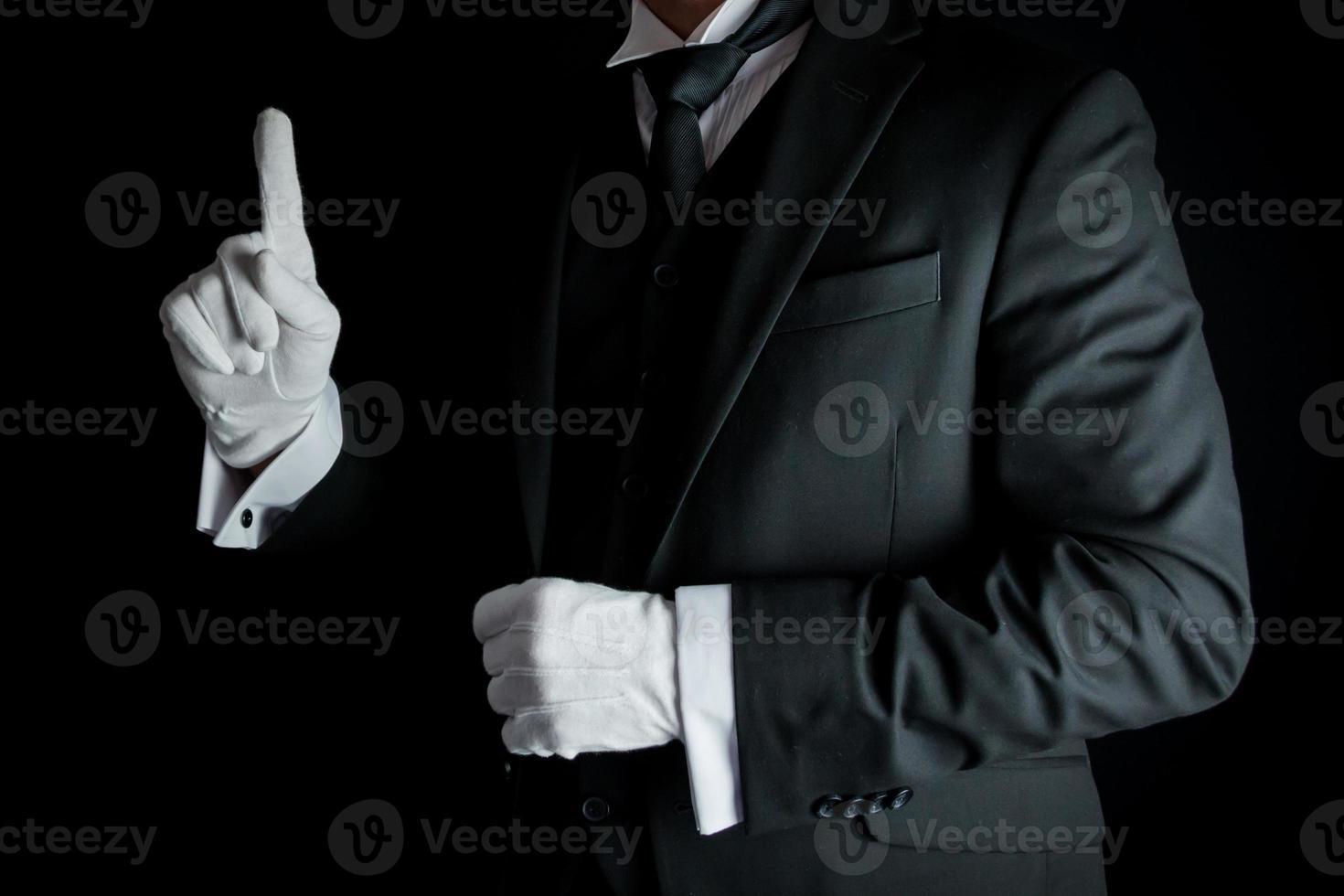 porträtt av butler i mörk kostym och vit handskar ivrig till vara av service. begrepp av service industri och professionell gästfrihet. foto
