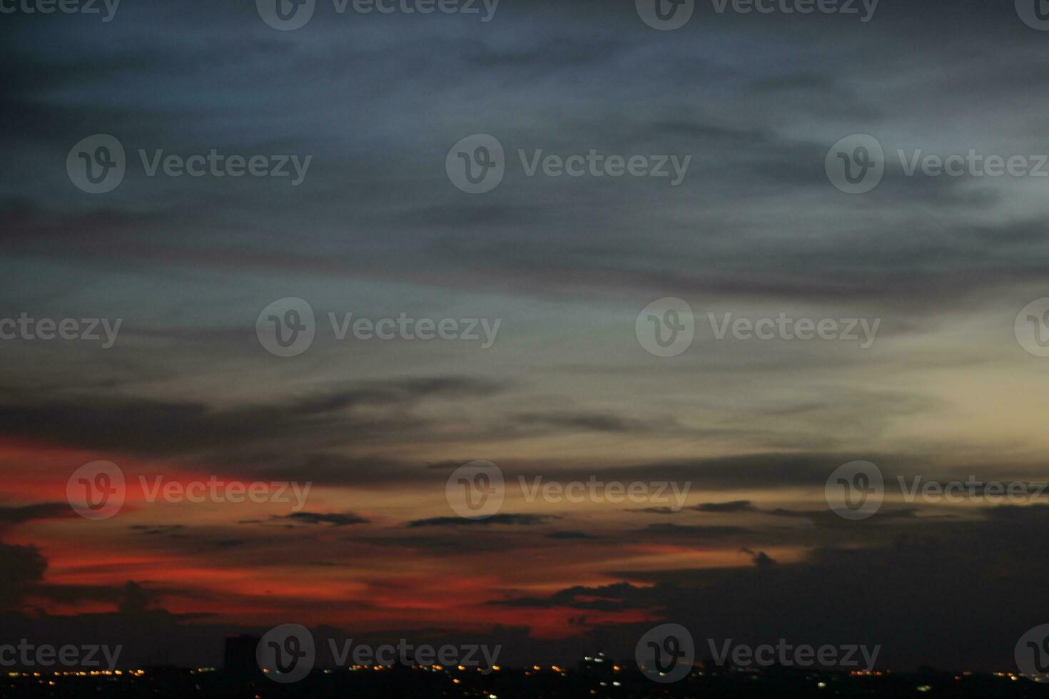 mörk blå moln med vit ljus solnedgång himmel bakgrund och stad ljus midnatt kväll tid foto