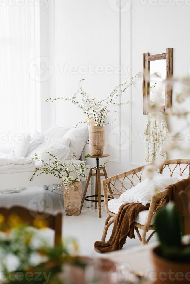 de interiör av en skön vit modern sovrum med vår blommor foto