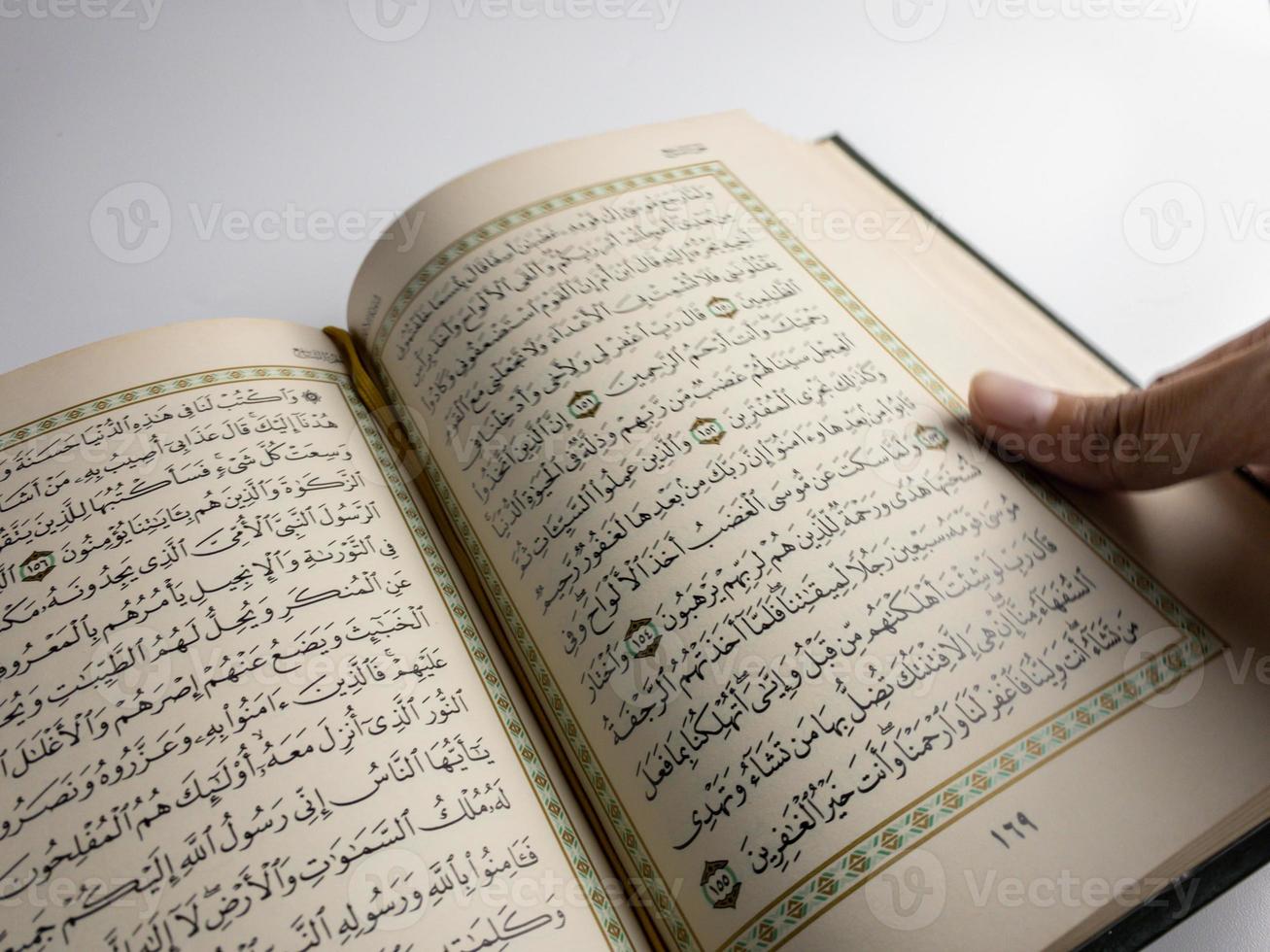 läsning al quran och vändning sida av quran ovan sajadah bön- matta isolerat på vit Plats. vald fokus foto