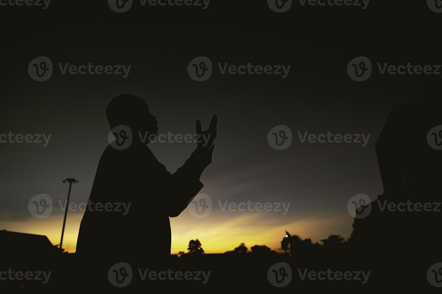 silhuett ung asiatisk muslim man bön- på solnedgång, ramadan festival begrepp foto