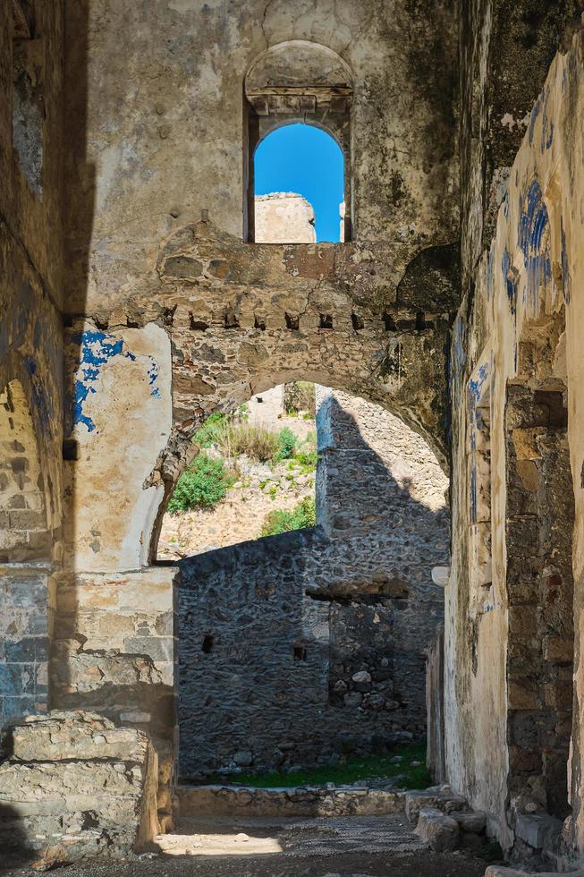 de ruiner av en grekisk katedral i ett övergiven spöke stad nära fethiye i Kalkon. vertikal ram, webbplats av de gammal grekisk stad av karmilisos 18: e århundrade, sommar semester säsong foto