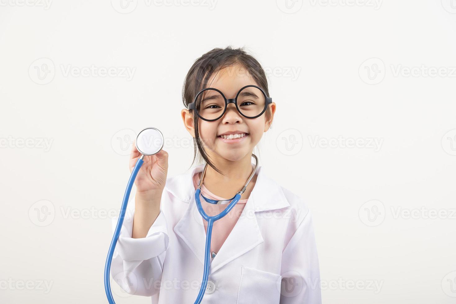 Asien liten flicka spelar läkare isolerat på vit foto