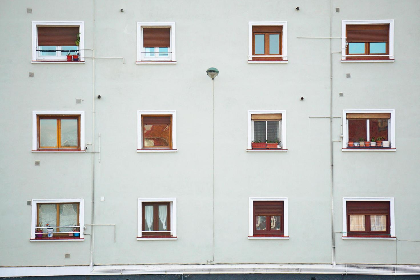 fönster på den vita fasaden av huset i staden Bilbao, Spanien foto