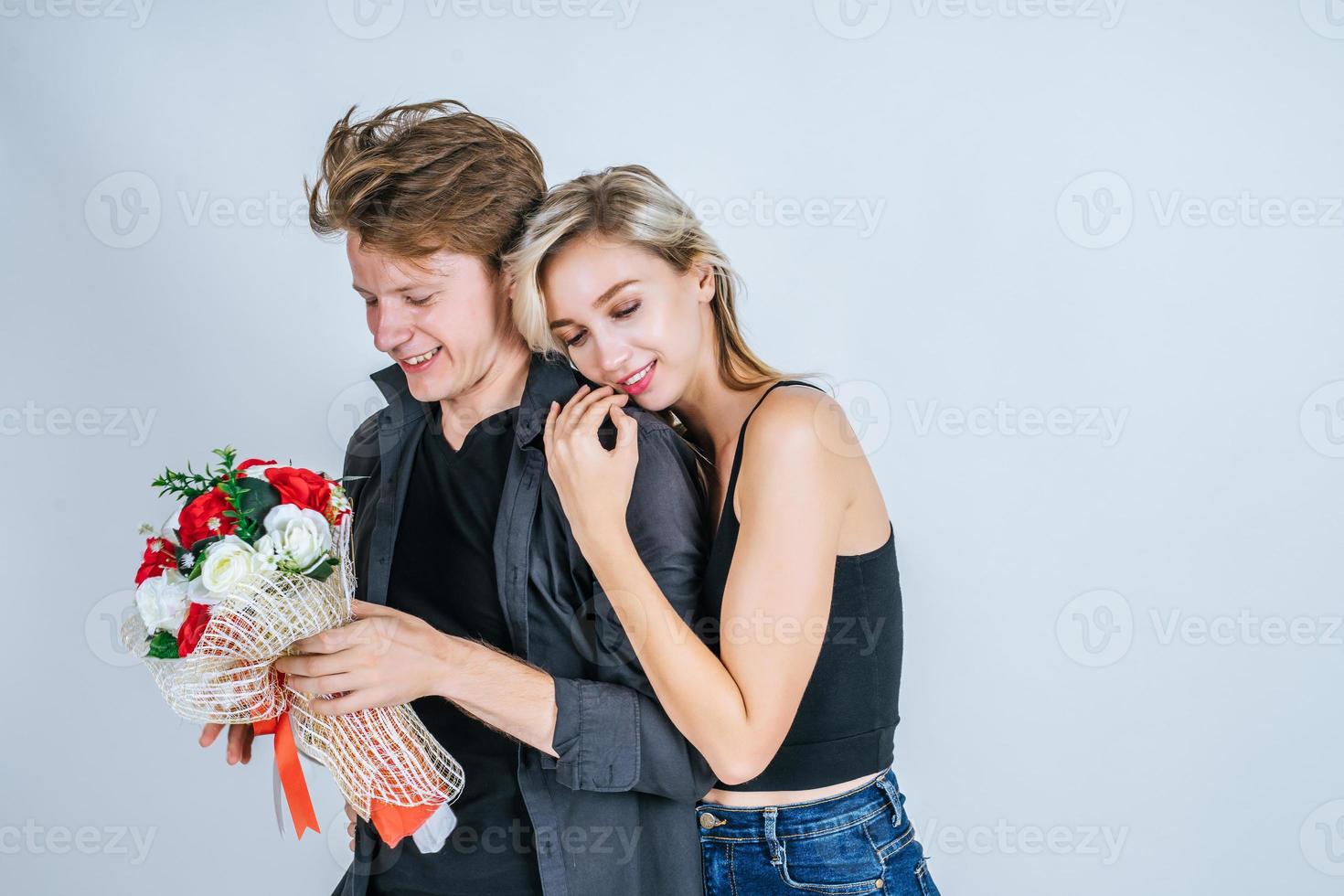 porträtt av lyckliga unga par med blommor i studio foto