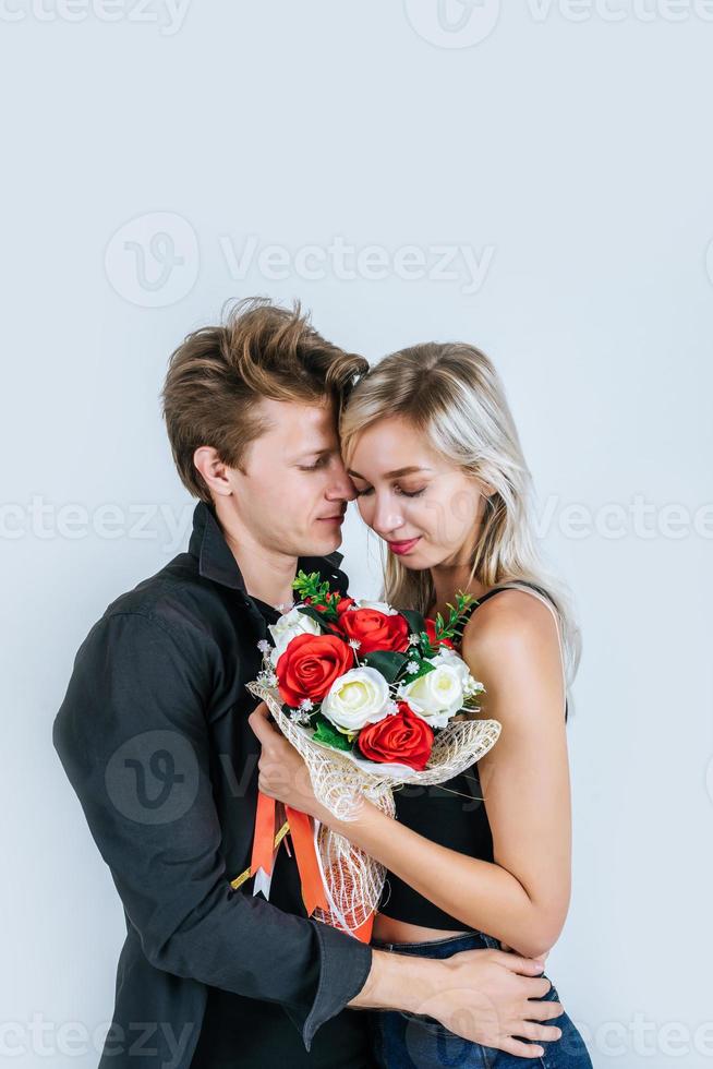 porträtt av lyckliga unga par med blommor i studio foto