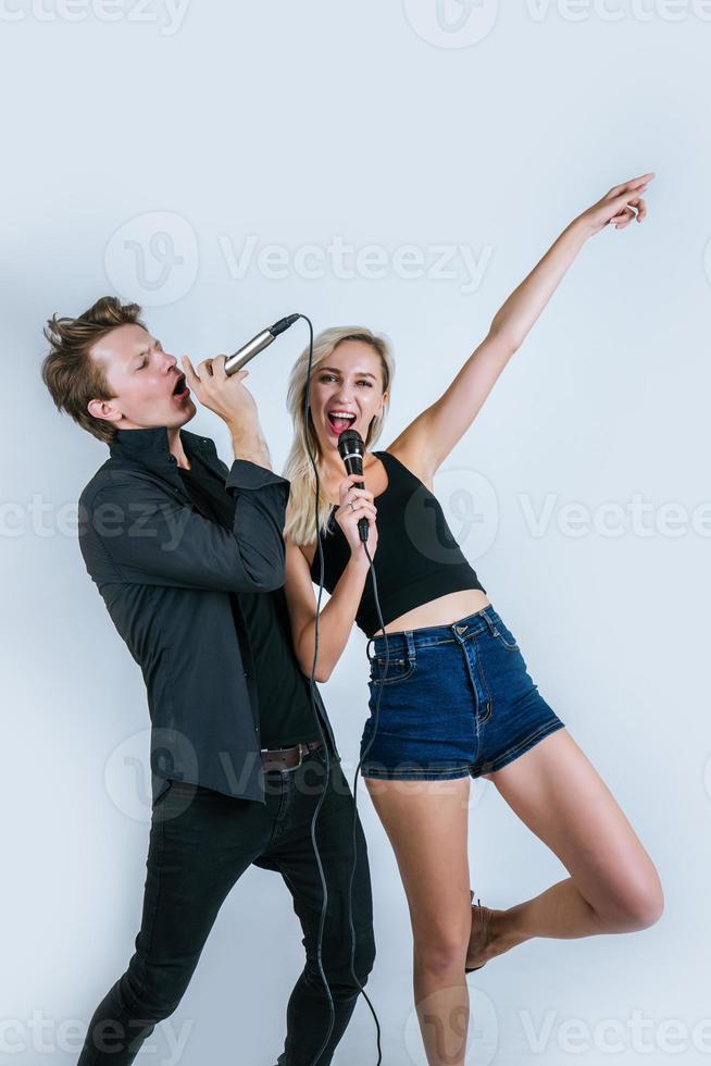 lyckligt porträtt av par som håller mikrofoner och sjunger foto