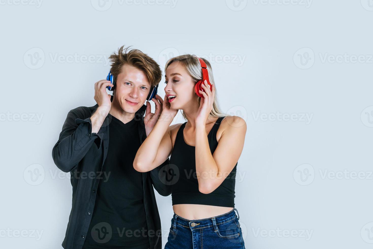 lyckligt ungt par i hörlurar lyssnar musik i studion foto