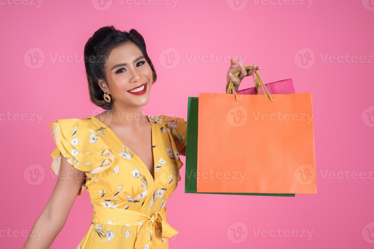 vacker asiatisk kvinna med färgade shoppingpåsar foto