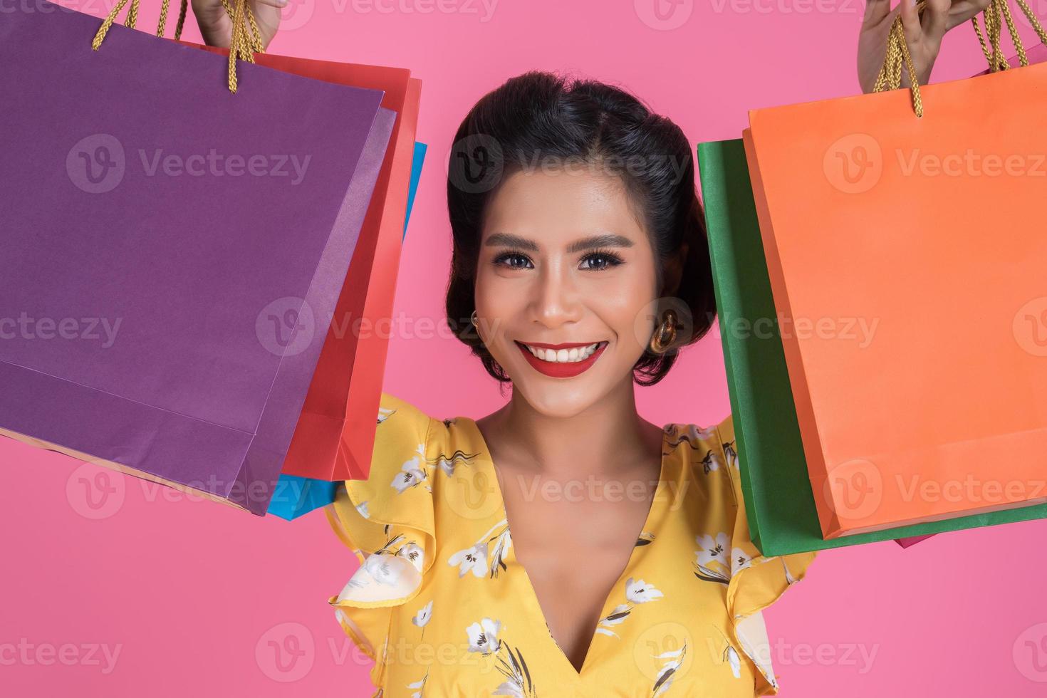 vacker asiatisk kvinna med färgade shoppingpåsar foto
