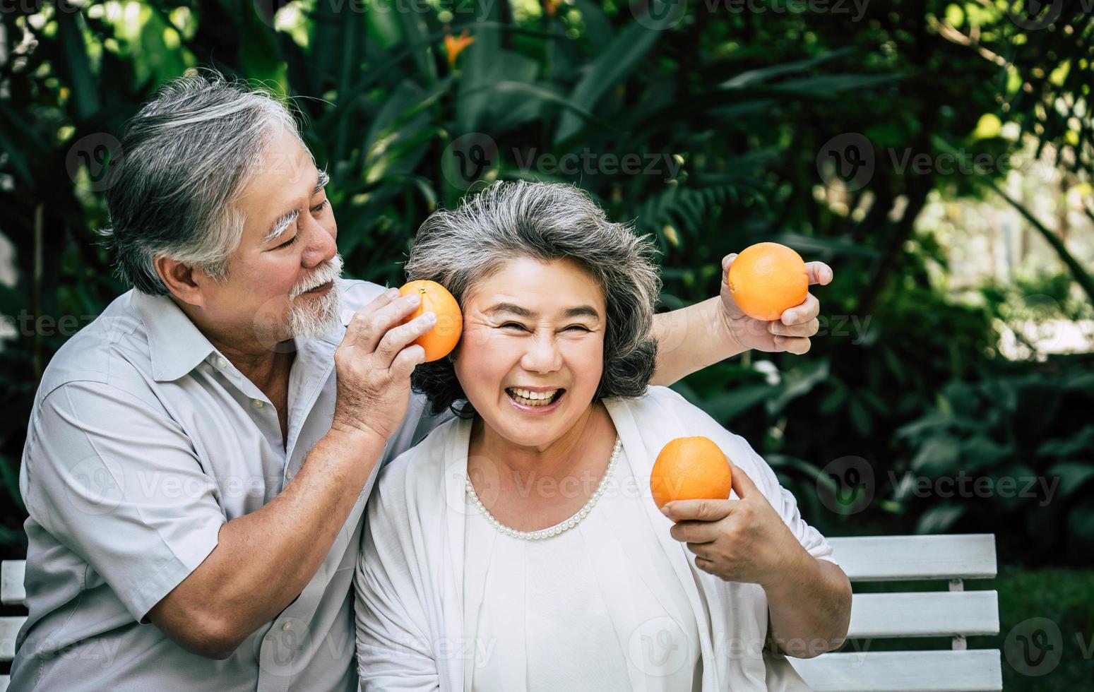 äldre par som leker och äter lite frukt foto