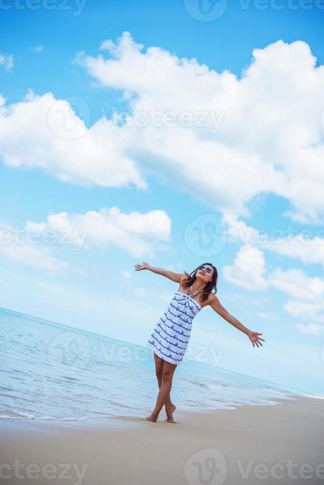 ung vacker glad kvinna njuter av stranden foto