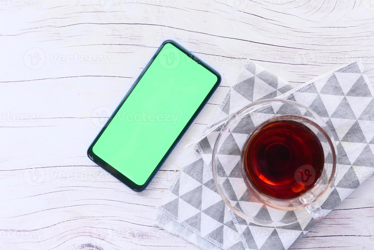 ovanifrån av en smart telefon och te på bordet foto