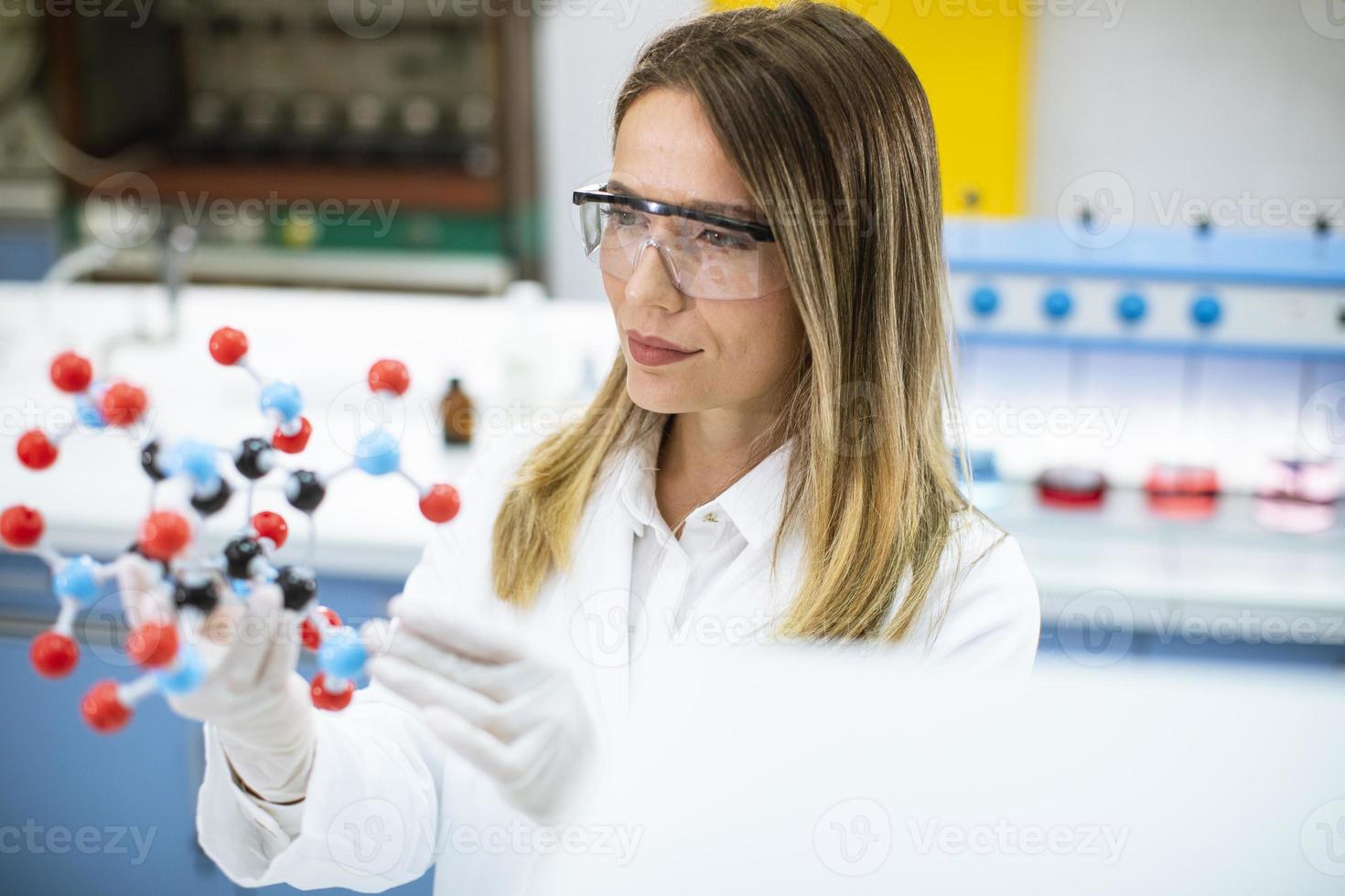 kvinnlig kemist håller molekylär modell i labbet foto