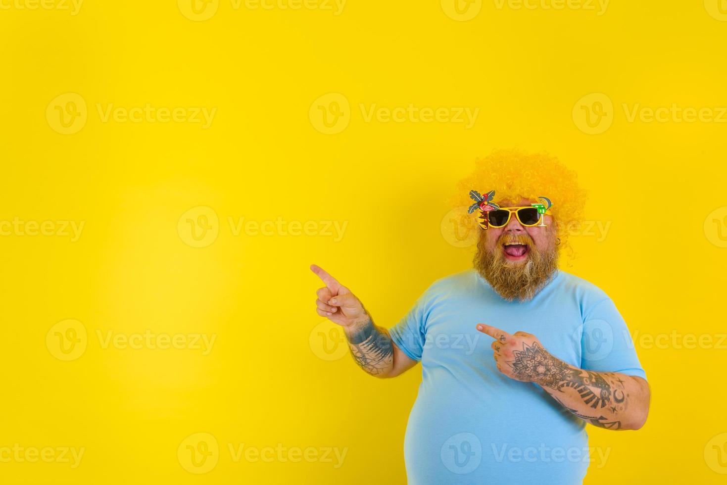 fett man med peruk i huvud och solglasögon pekar på med händer något foto