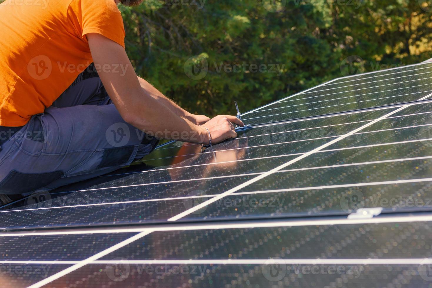 arbetare montera energi systemet med sol- panel för elektricitet och varm vatten foto