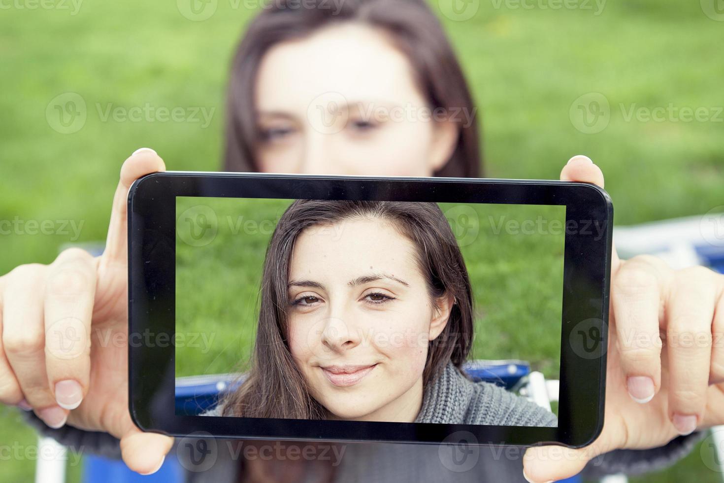 Söt ung kvinna ta en selfie med smart telefon foto