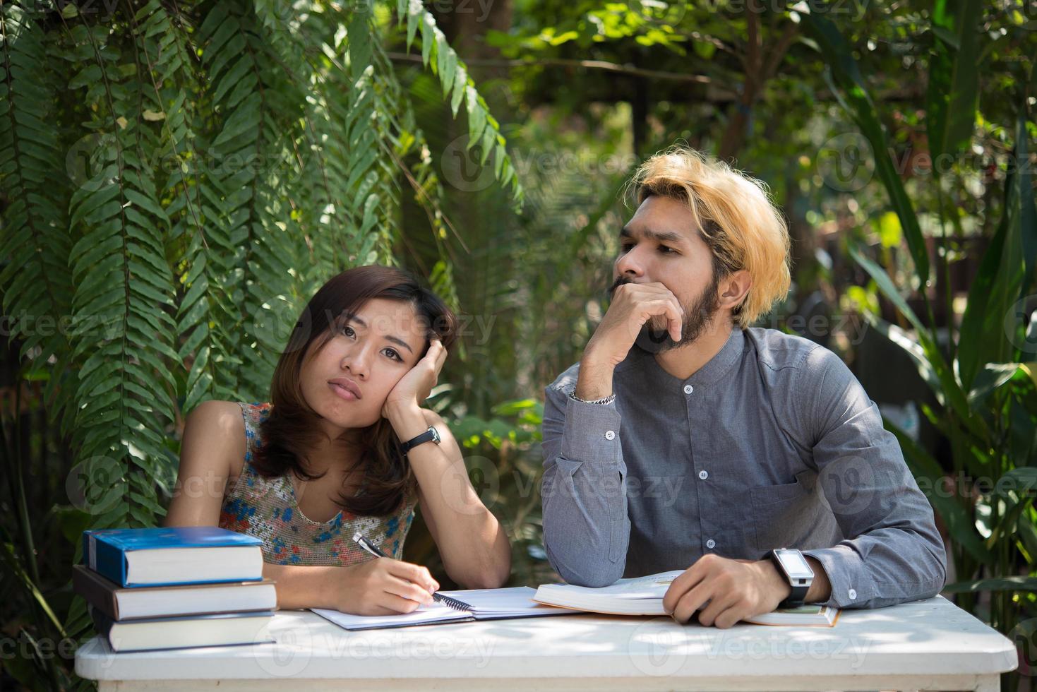 utbildning par sitter vid natur hem trädgård läsa för examen tillsammans foto