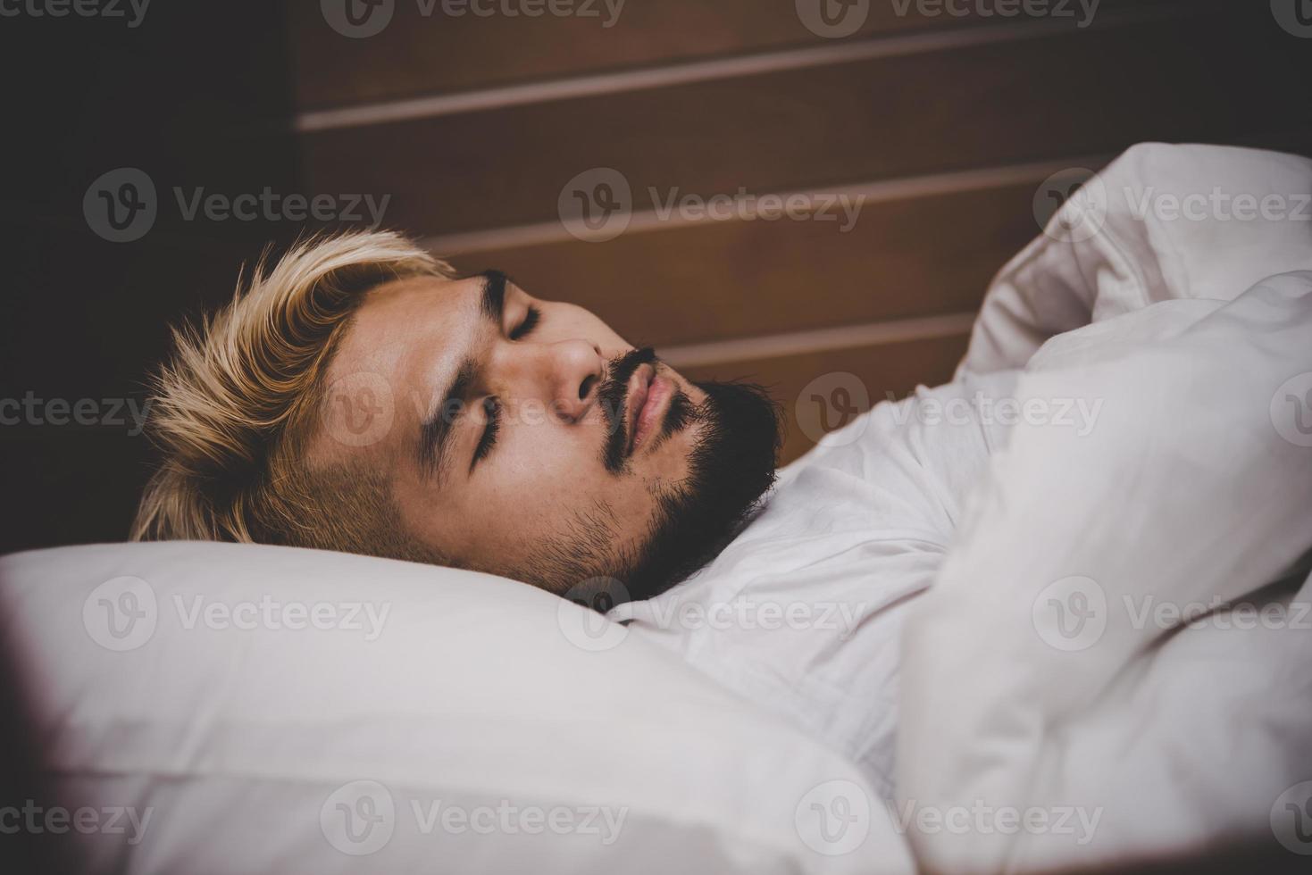 stilig ung skägg man sover foto