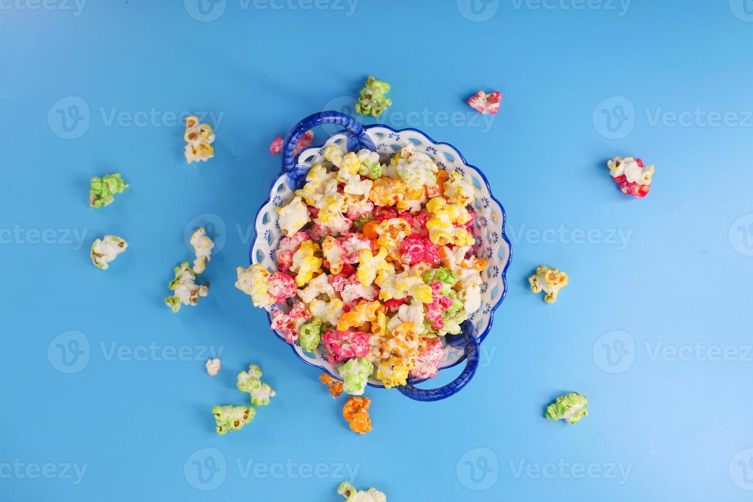 färgglad popcorn i en skål på blå bakgrund foto
