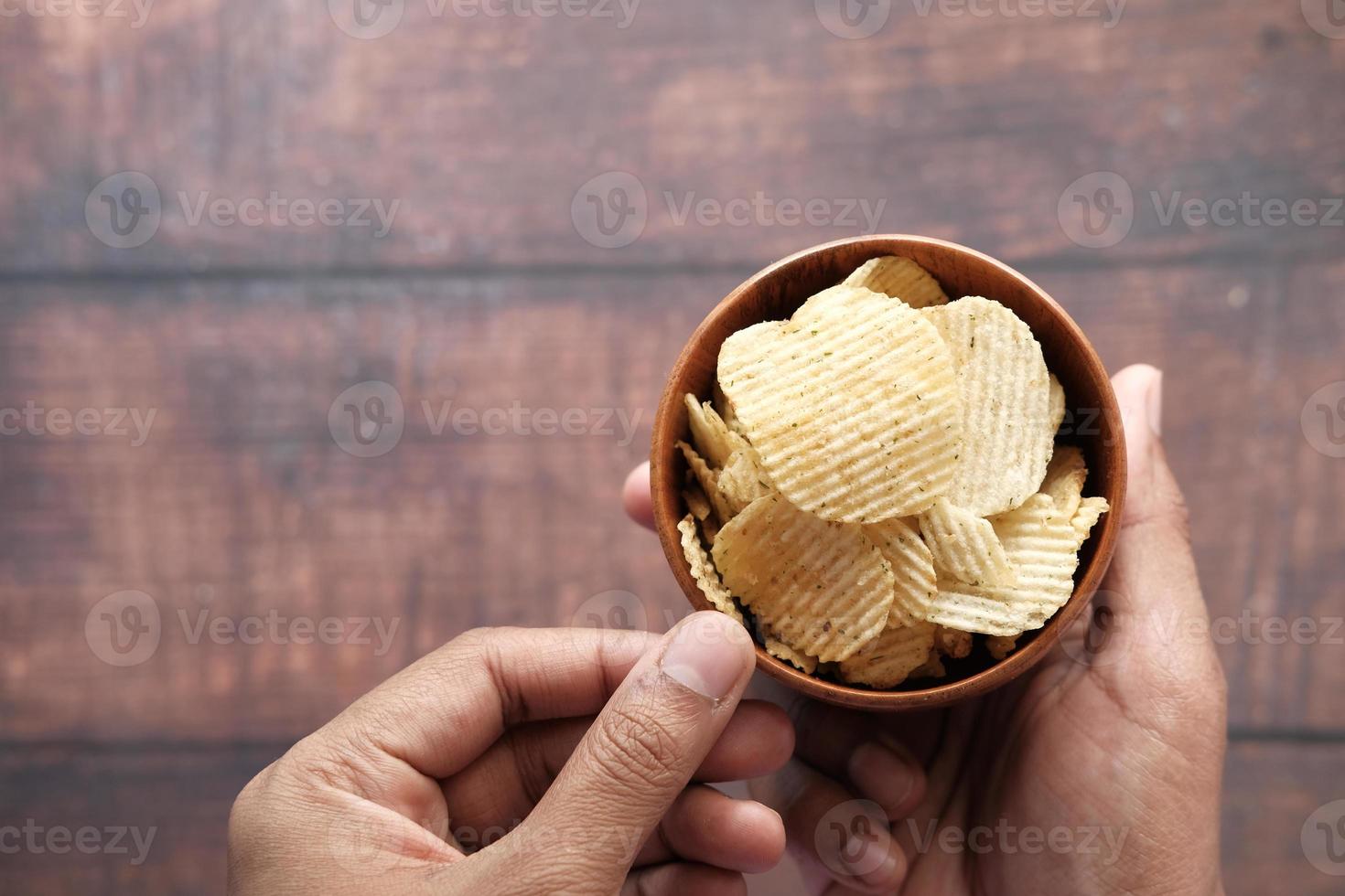 ovanifrån av manhand som äter potatischips foto