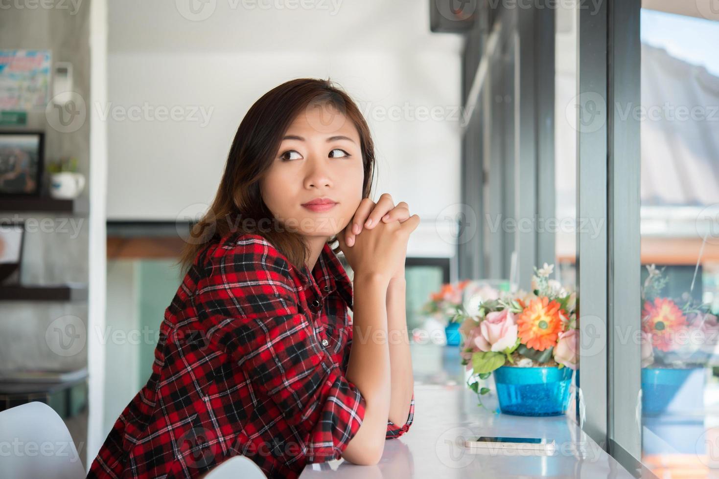 vacker asiatisk kvinna som sitter på ett kafé foto