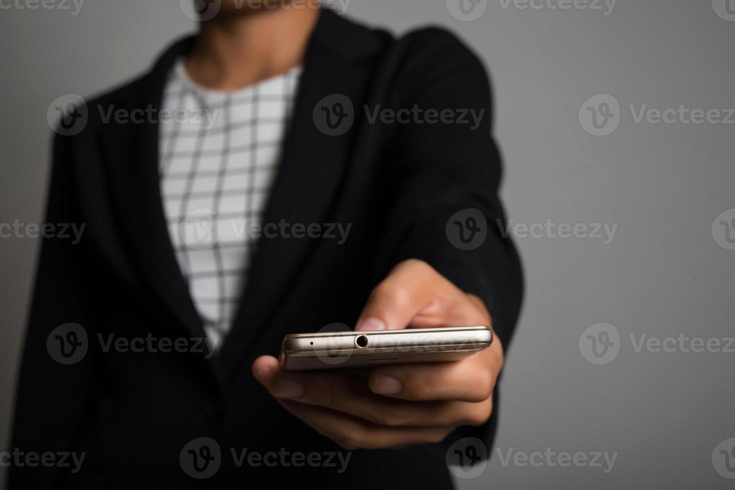 ung affärskvinna som använder mobiltelefonen som isoleras på svart bakgrund foto