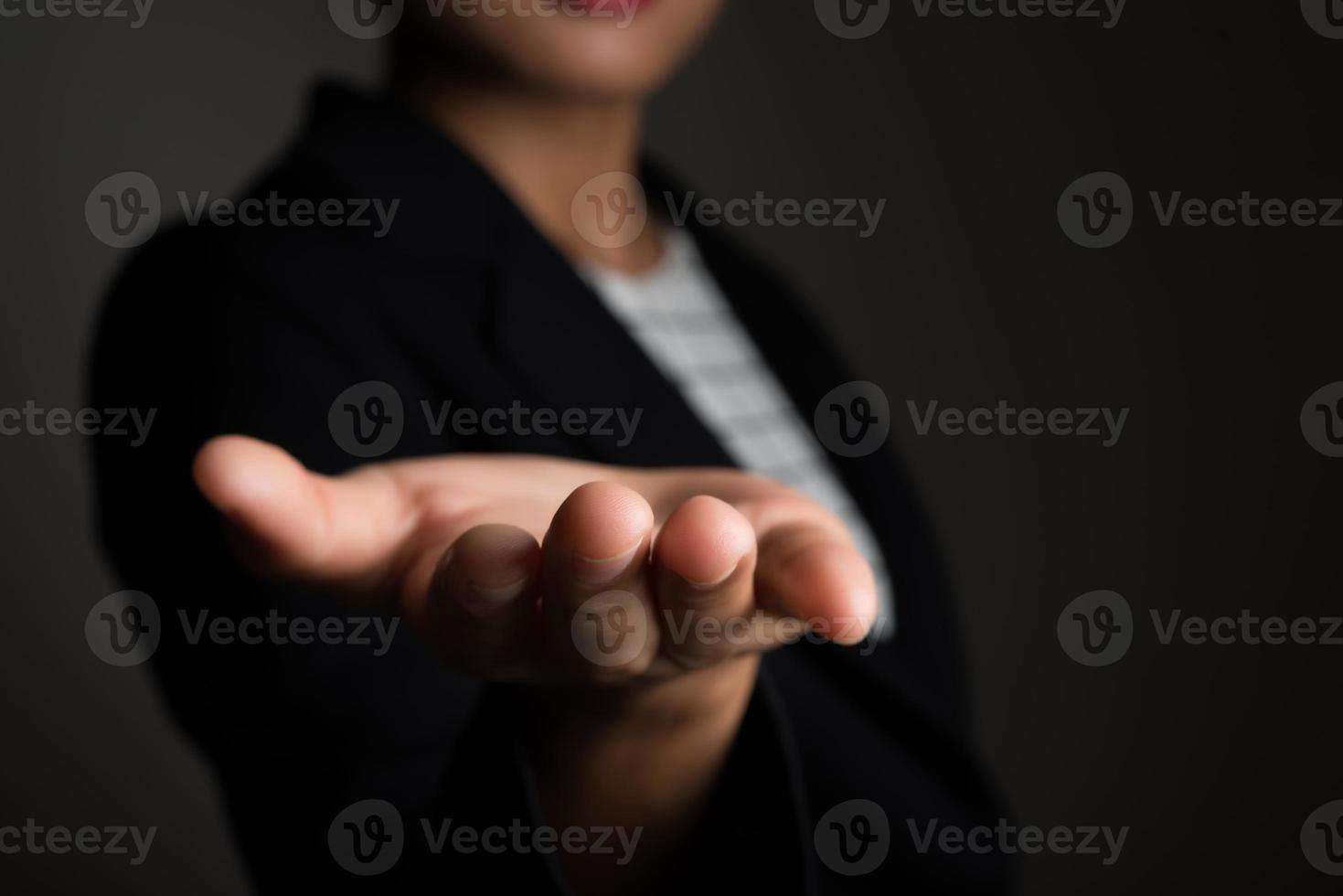 affärskvinnas hand visar tomt område för tecken eller copyspace, isolerad på svart bakgrund foto