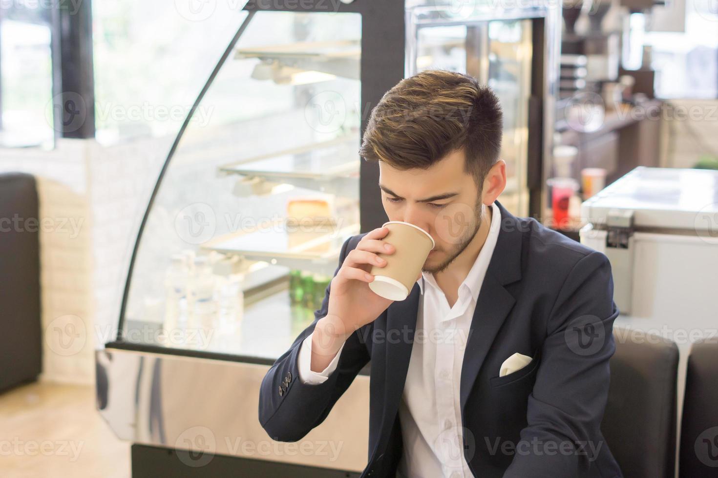 ung affärsman som dricker kaffe foto