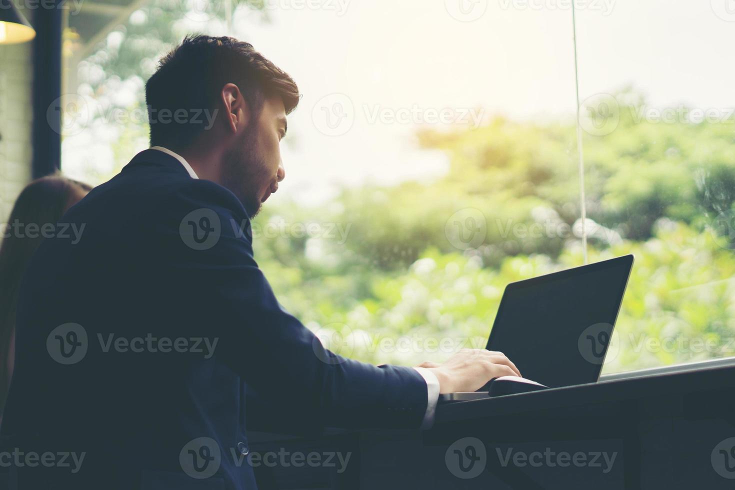 ung affärsman som arbetar på bärbara datorn på kontoret foto