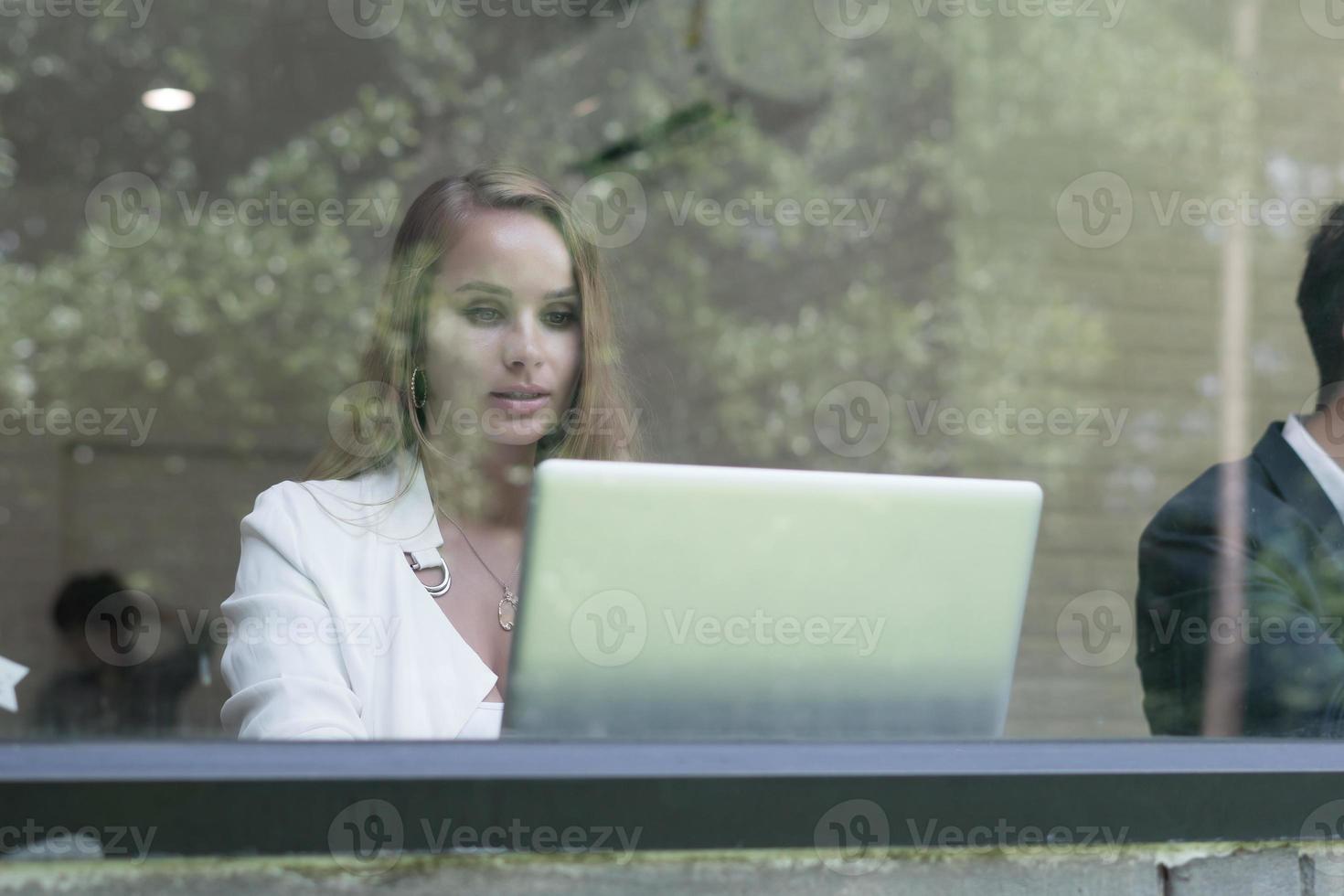 ung affärskvinna som arbetar på sin bärbara dator på kontoret foto