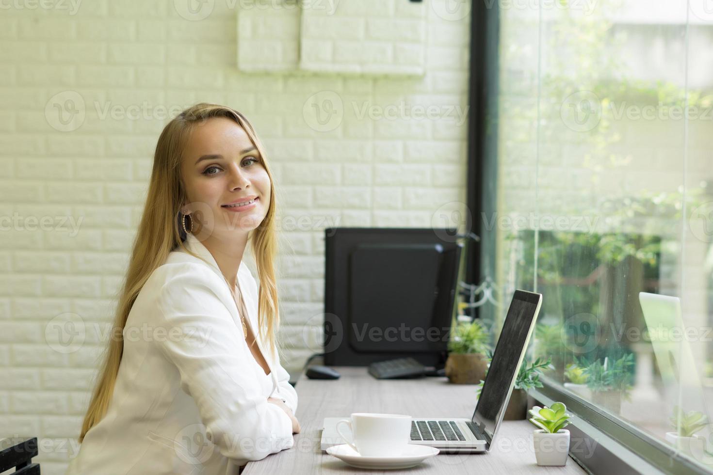 ung affärskvinna som arbetar på sin bärbara dator på kontoret foto