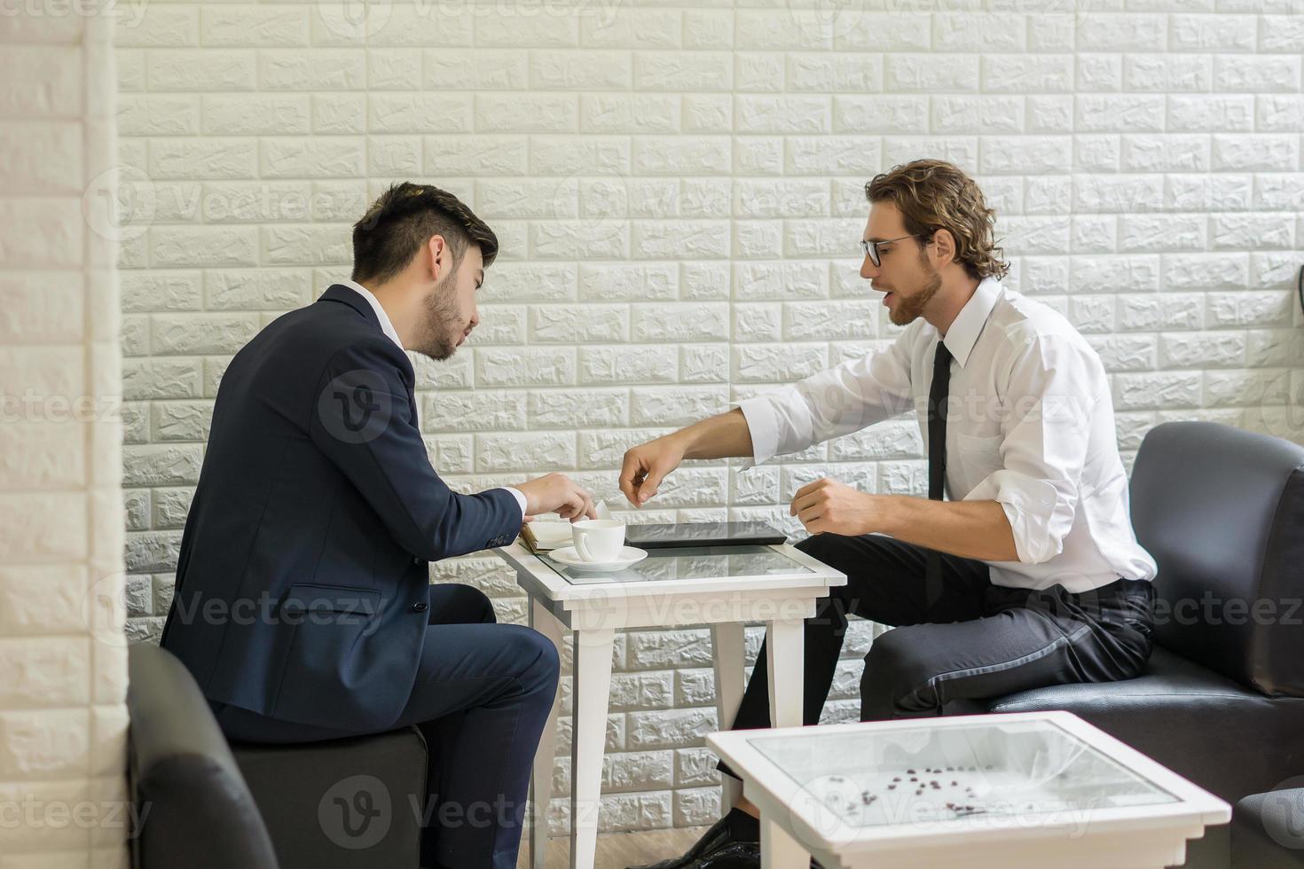 ung affärsman som pratar med kollega i en modern affärslounge foto