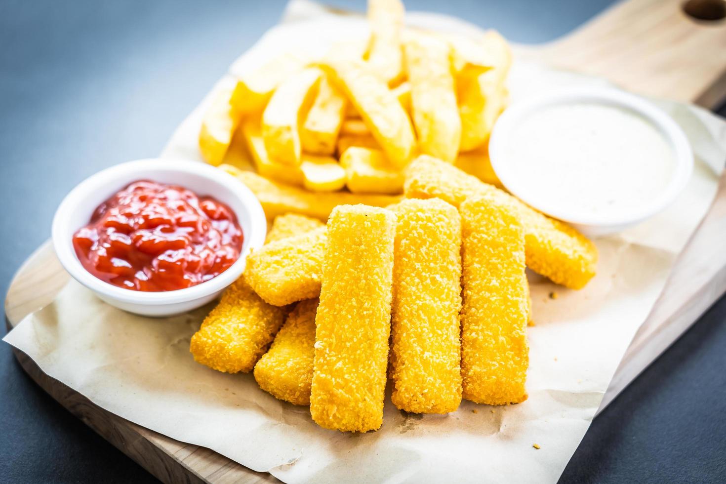 fiskfinger och pommes frites med ketchup och majonnässås foto