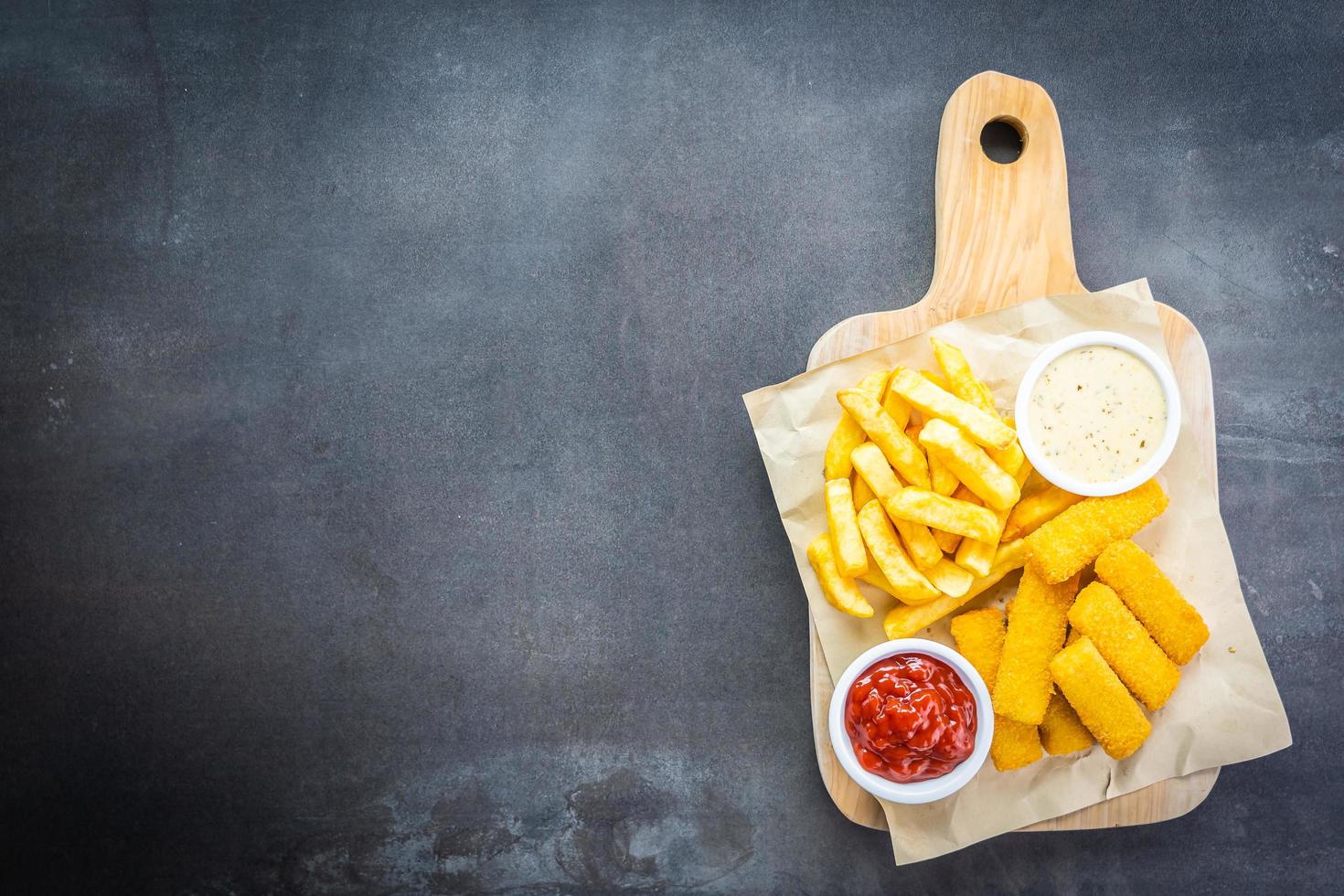 fiskfinger och pommes frites med ketchup och majonnässås foto