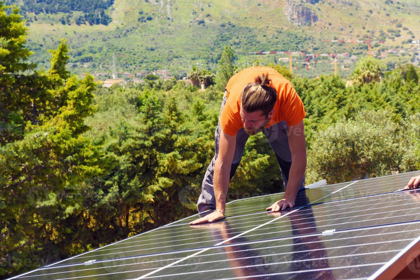 arbetare montera energi systemet med sol- panel för elektricitet foto