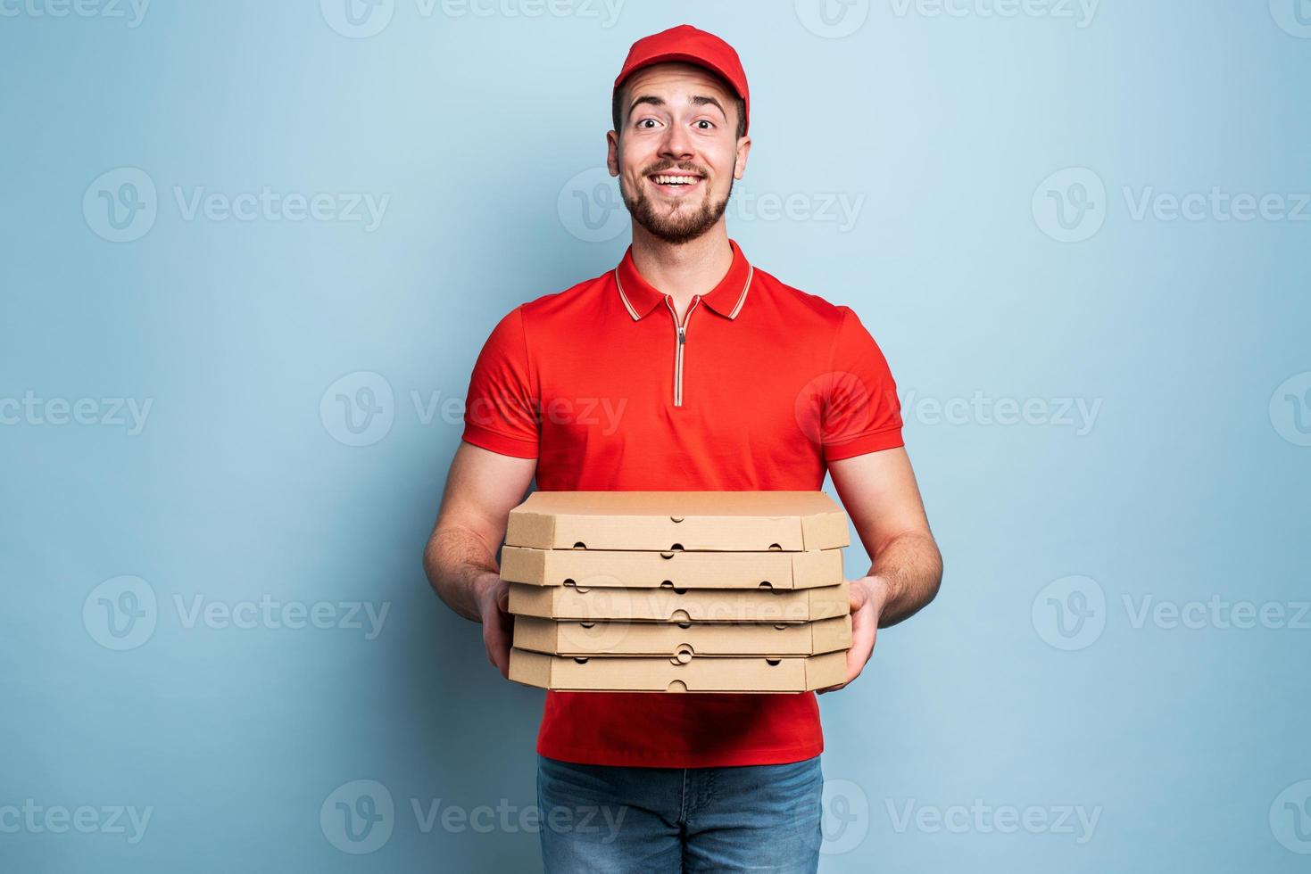 Lycklig deliveryman Lycklig till levererar pizza med Framgång. cyan bakgrund foto