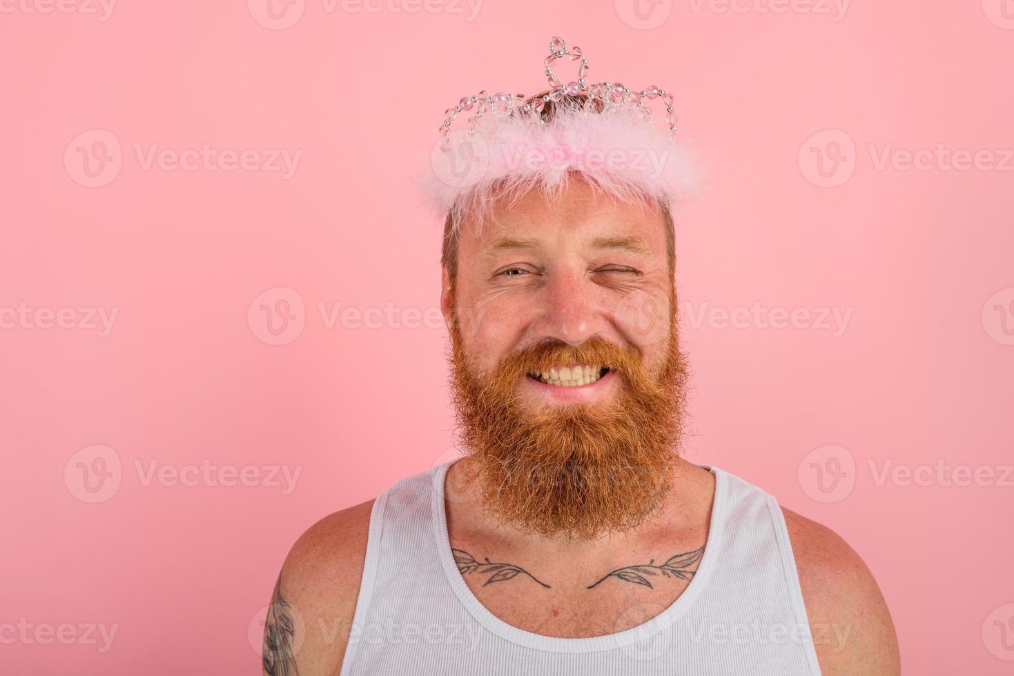 Lycklig man med skägg , tatueringar och krona handlingar tycka om en prinsessa foto