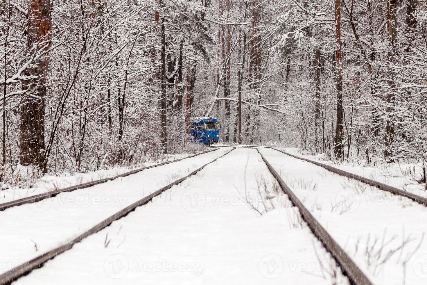 ett gammal spårvagn rör på sig genom en vinter- skog foto