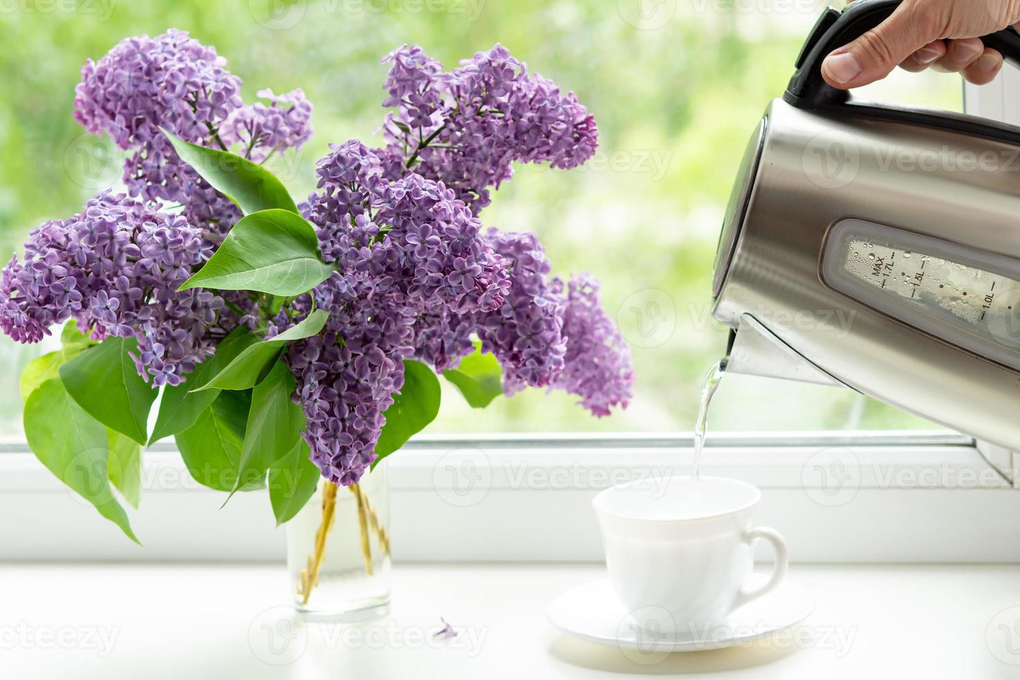 Hem interiör med en bukett av blomning lila blommor på de fönster. foto