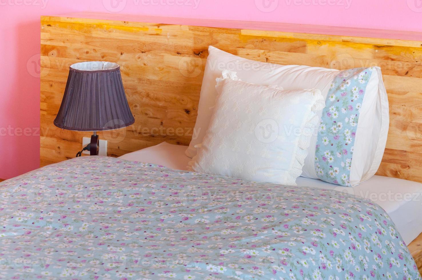 interiör stil i sovrum, modern trä säng, kudde på säng dekoration i skön sovrum interiör foto