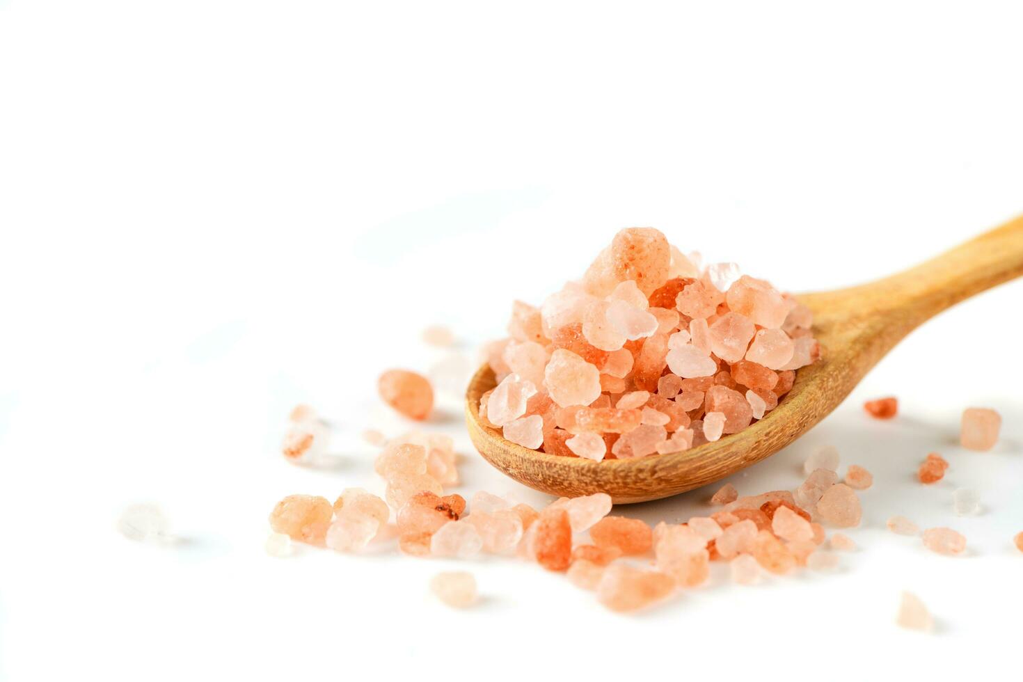 himalayan sten rosa salt på trä sked isolerat på vit foto