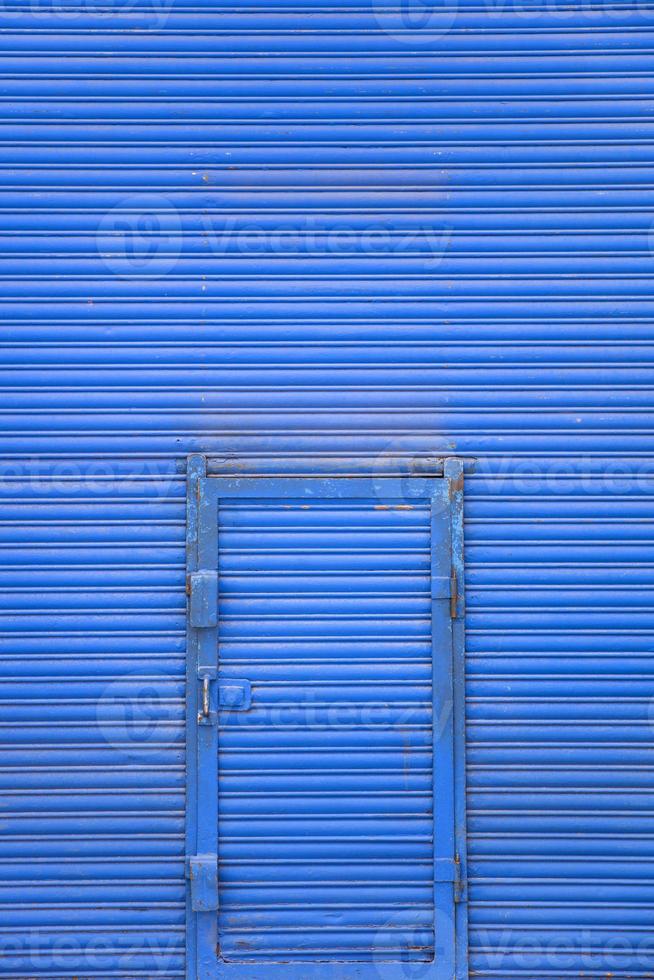 blå metalldörr på den blå väggen foto