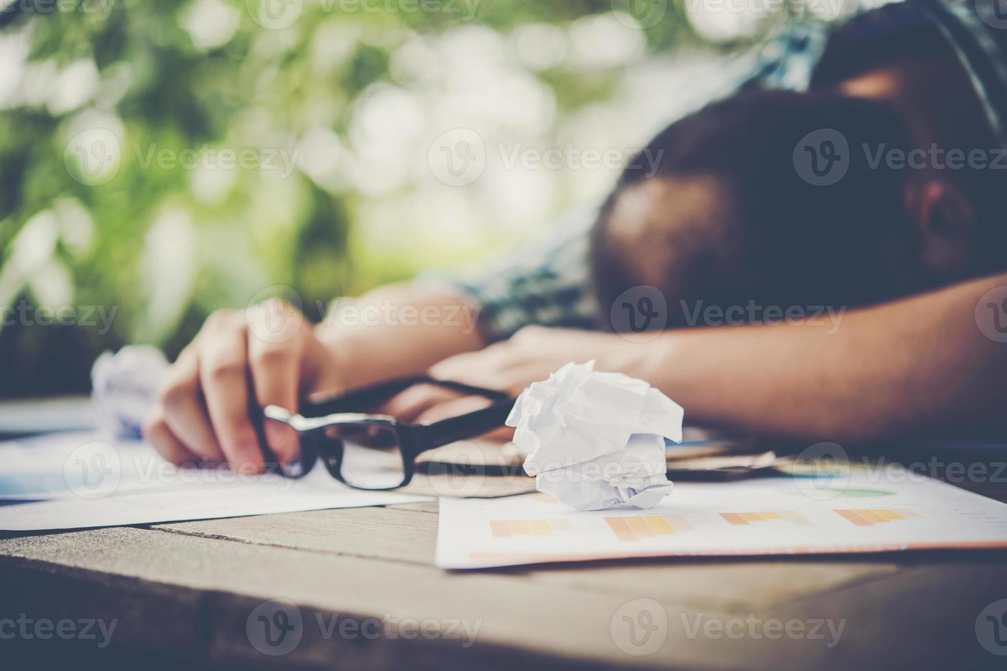 trött arbetande man som sover på arbetsplatsen foto