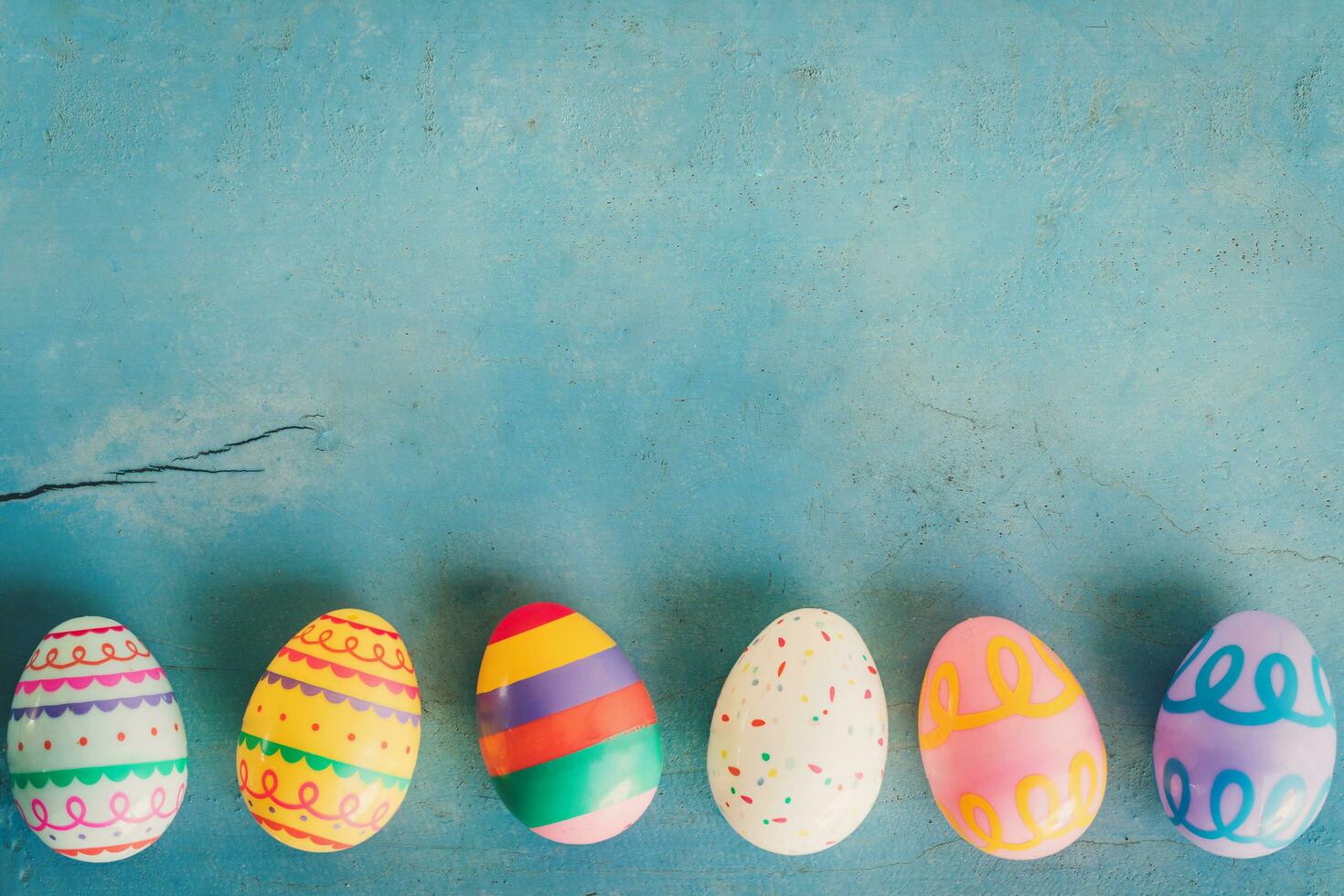 färgrik påsk ägg på blå pastell Färg trä bakgrund med Plats. foto